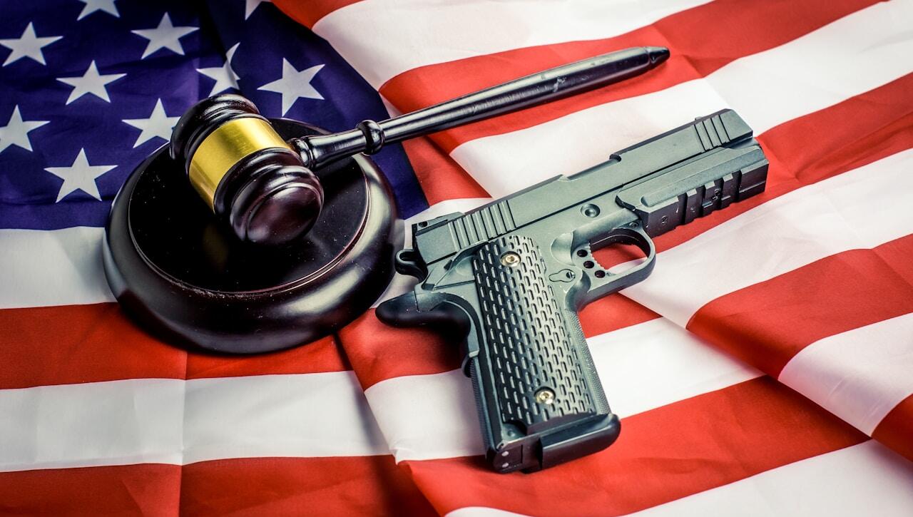 a gun, a judge's hammer, and an american flag